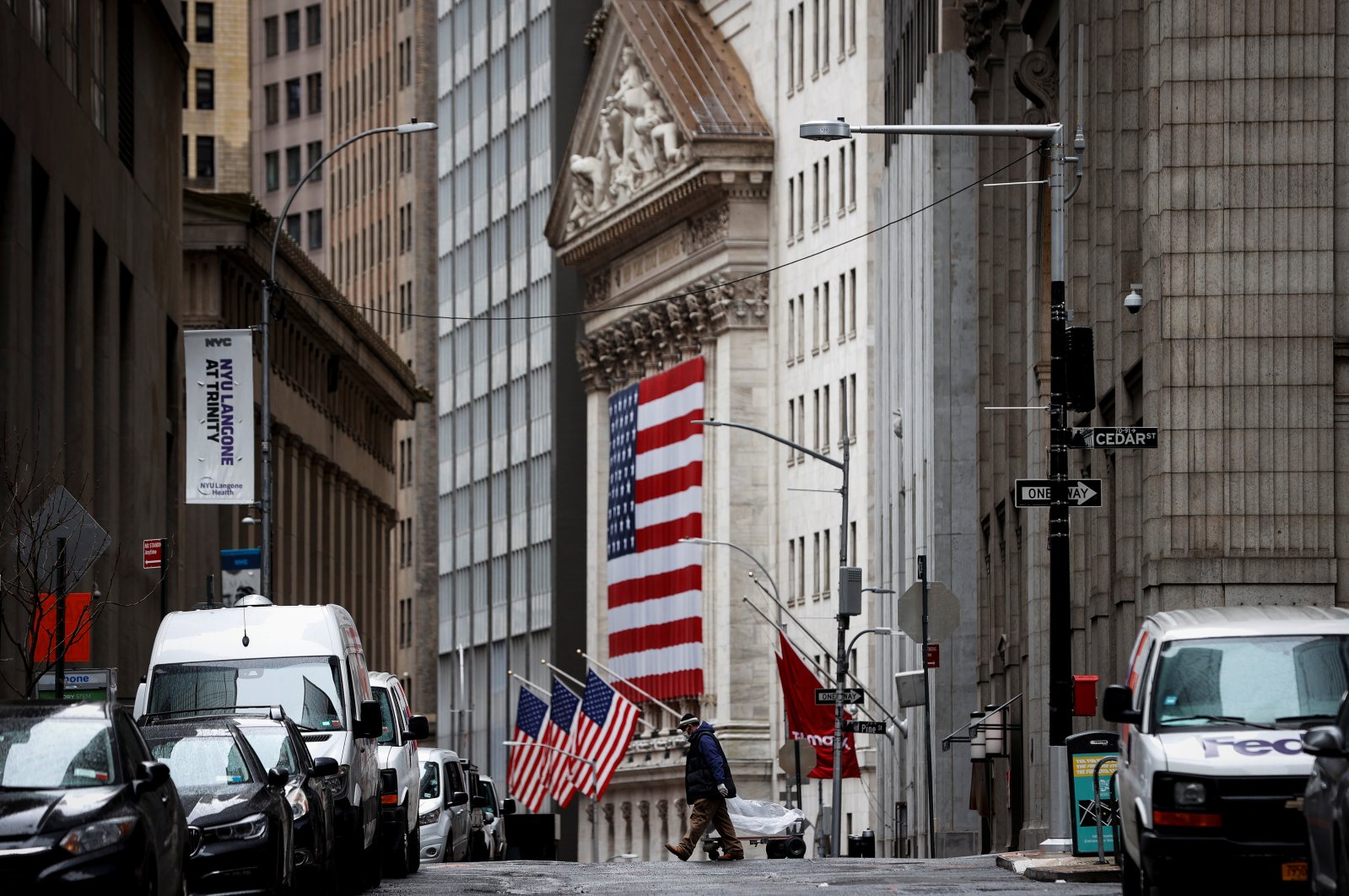 A man crosses a nearly deserted Nassau Street in front of the New York Stock Exchange (NYSE) in the financial district of lower Manhattan during the outbreak of COVID-19 in New York City, New York, U.S., Friday, April 3, 2020. (Reuters Photo)