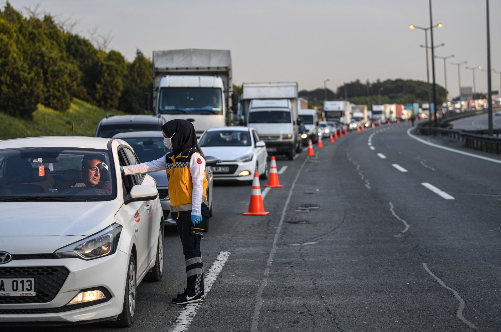 A Turkish health official checks the temperature of a driver at a checkpoint on the Asian side of Istanbul, Tuesday, March 30, 2020. (AFP Photo)