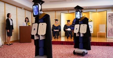 Ipads attached to 'newme' robots replacing graduating students' presence at a ceremony, wear graduation gowns and hats in Tokyo, Japan, Saturday, March 28, 2020. (Reuters Photo)