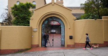 A woman walks her dog past the Carmelite Monastery in Melbourne, Australia, Tuesday, April 7, 2020, where Cardinal George Pell is staying after having been released from Barwon Prison earlier in the day. (AFP Photo)