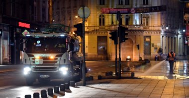 Bosnian sanitation workers use curfew hours to wash streets with water and sanitizing solution, in Sarajevo, late on April 4, 2020. (AFP Photo)