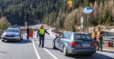 A driver presents documents to an Austrian policeman, March 2020 in Soelden, where people were filtered after the Tyrol town was quarantined due to the novel coronavirus epidemic. (AFP File Photo)