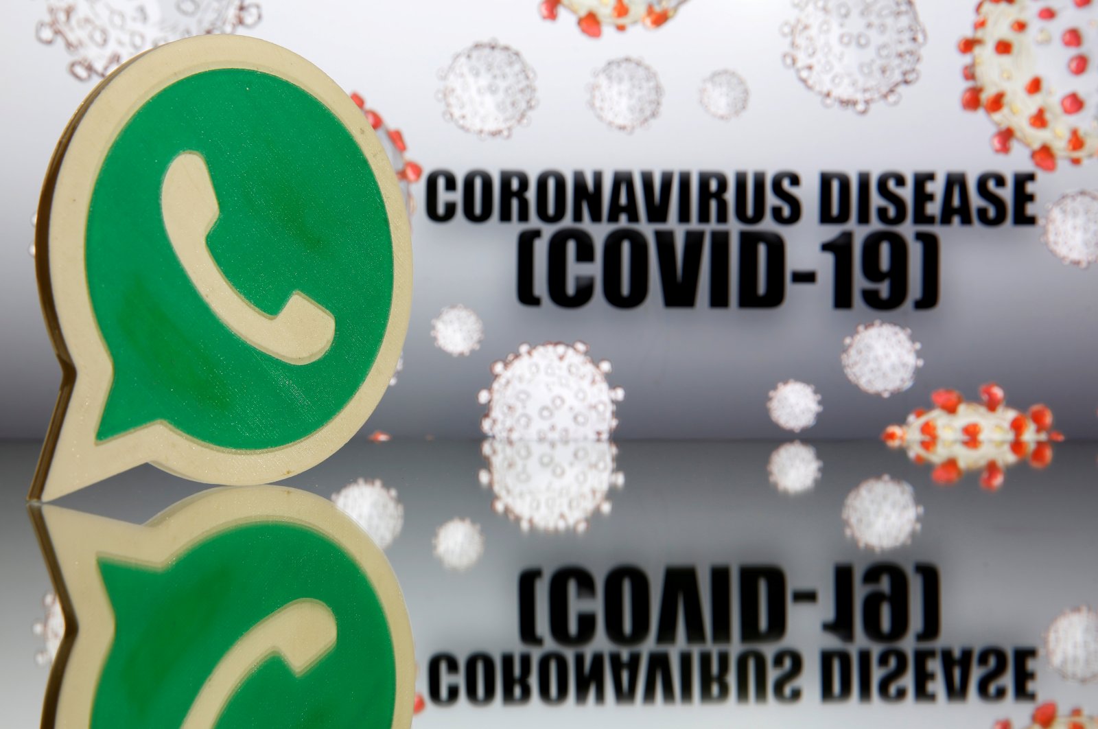 A 3D-printed Whatsapp logo embellishes a coronavirus disease (COVID-19) sign in this illustration from March 19, 2020. (Reuters Photo)