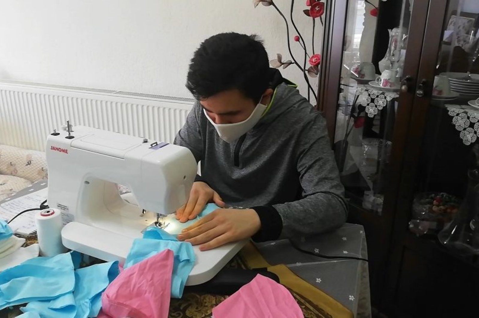 Abdil Semih Ağdacı, a 16-year-old high school student and a volunteer, sews masks at home, in Afyon, Turkey, Tuesday, April 7, 2020. (İHA Photo) 