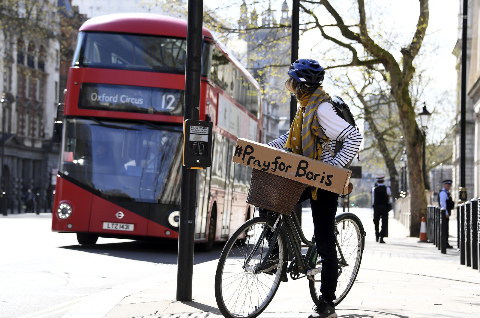 A woman shows a sign on her bicycle as British Prime Minister Boris Johnson is in intensive care fighting the coronavirus in London, Tuesday, April 7, 2020. (AP Photo)