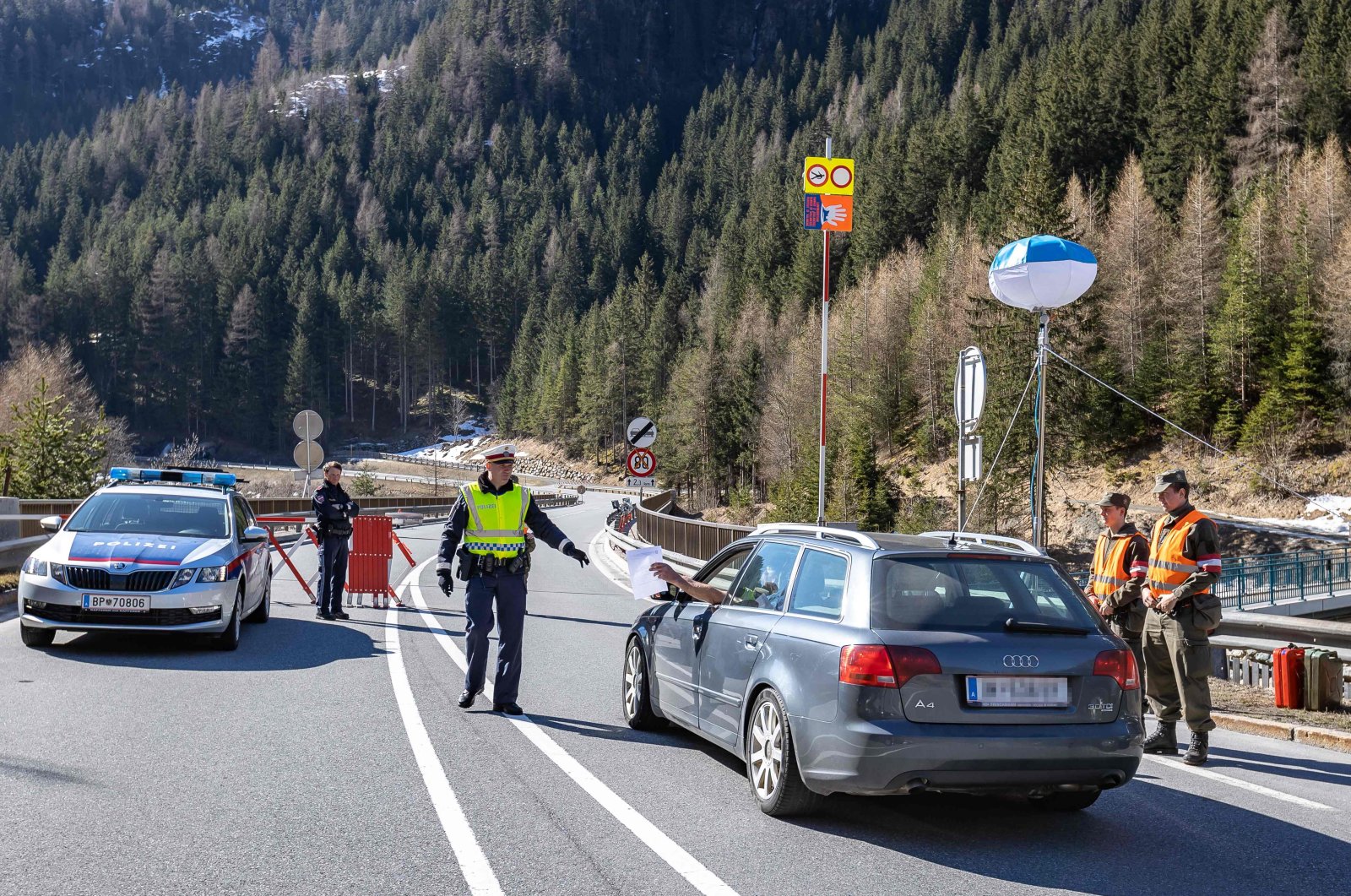 A driver presents documents to an Austrian policeman, March 2020 in Soelden, where people were filtered after the Tyrol town was quarantined due to the novel coronavirus epidemic. (AFP File Photo)