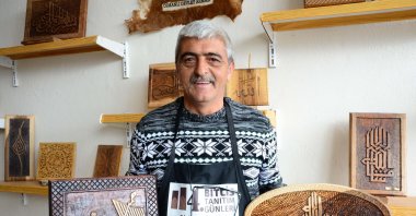In this undated photo, Osman Gülsar poses with some of his works at his workshop in Bitlis, Turkey. (AA Photo)