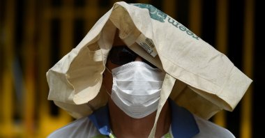 A man wears a face mask as a preventive measure against the spread of the novel coronavirus, COVID-19, as he lines up outside a supermarket in Cali, Colombia, on April 6, 2020. (AFP Photo)