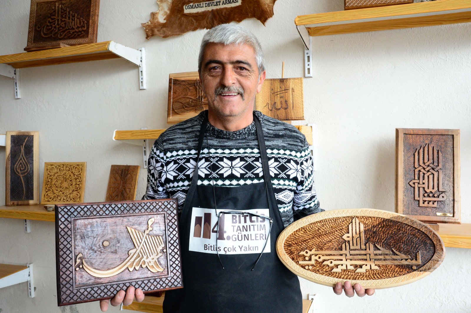 In this undated photo, Osman Gülsar poses with some of his works at his workshop in Bitlis, Turkey. (AA Photo)