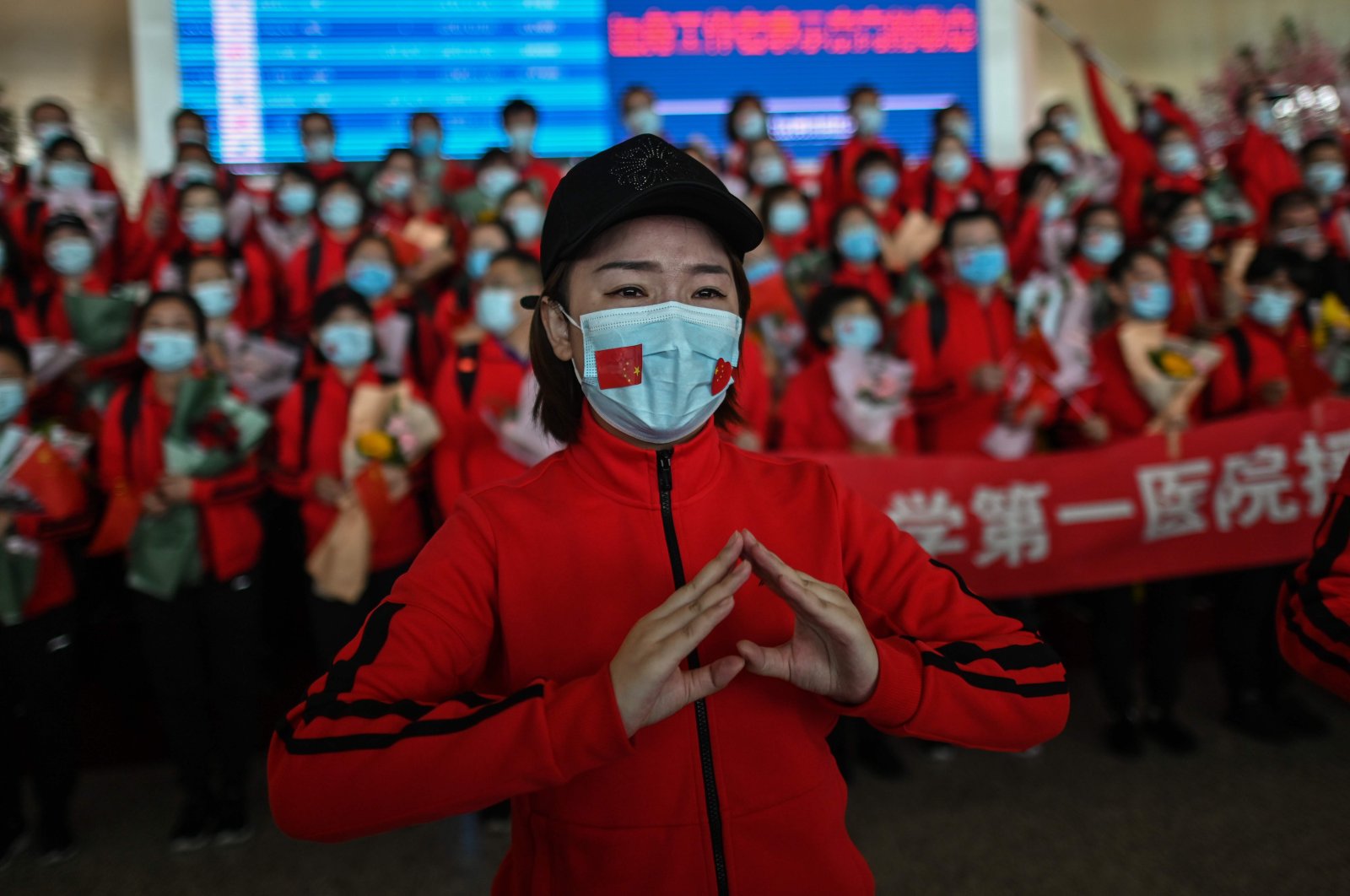 A medical worker from Jilin province tears up during a ceremony as Tianhe Airport is reopened in Wuhan, Hubei province, China, Wednesday, April 8, 2020. (AFP Photo)