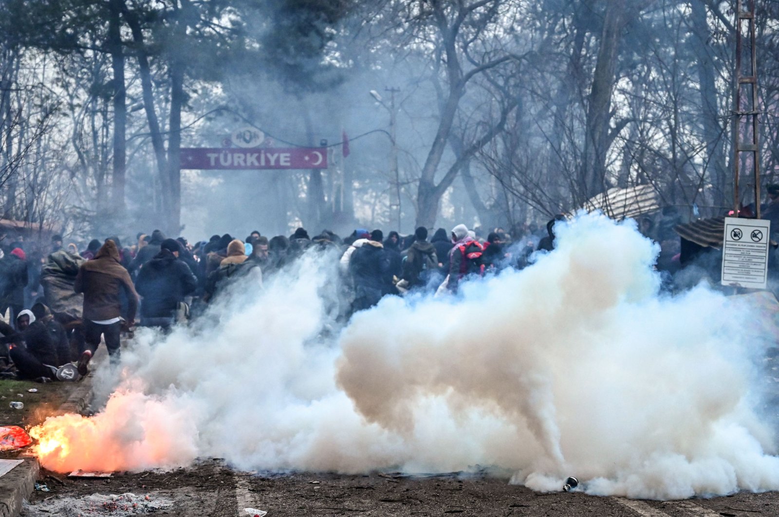 Migrants run away as Greek anti-riot police officers use tear gas in the buffer zone at the Turkey-Greece border, at Pazarkule, Turkey's Edirne province, Feb. 29, 2020. (AFP Photo)