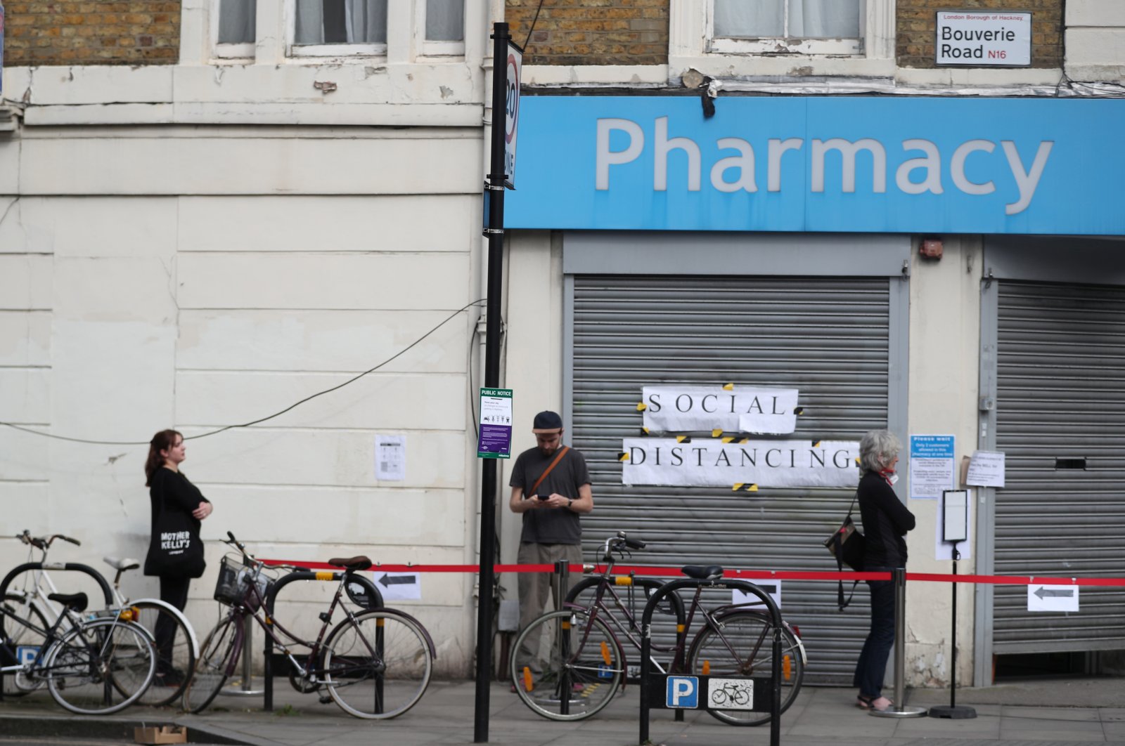 People are seen following social distancing rules as they queue outside a pharmacy in Stoke Newington, London, April 8, 2020. (REUTERS Photo)