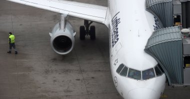 An employee at the Franz-Josef-Strauss airport walks past a plane belonging to German airline Lufthansa, Nov. 24, 2016, Munich. (AFP Photo)