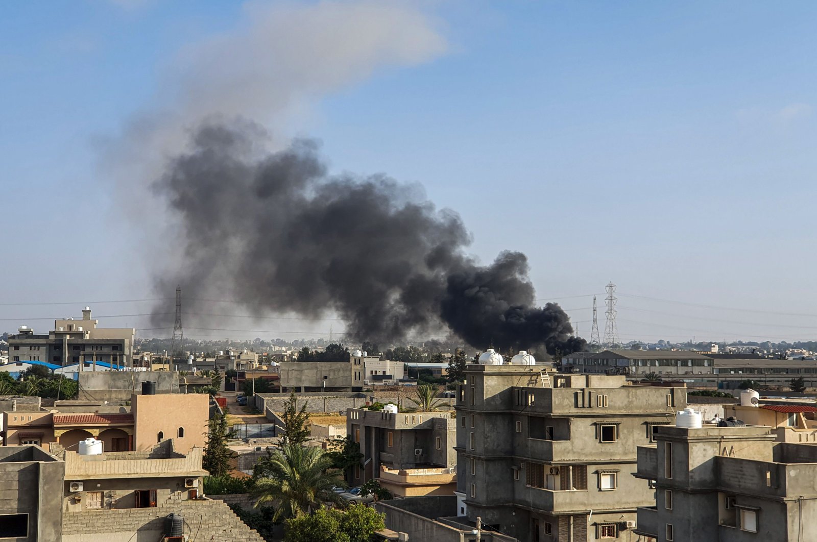 This picture taken on June 29, 2019, shows smoke plumes rising in Tajoura, south of the Libyan capital Tripoli, following a reported airstrike by forces loyal to warlord Khalifa Haftar. (AFP Photo)
