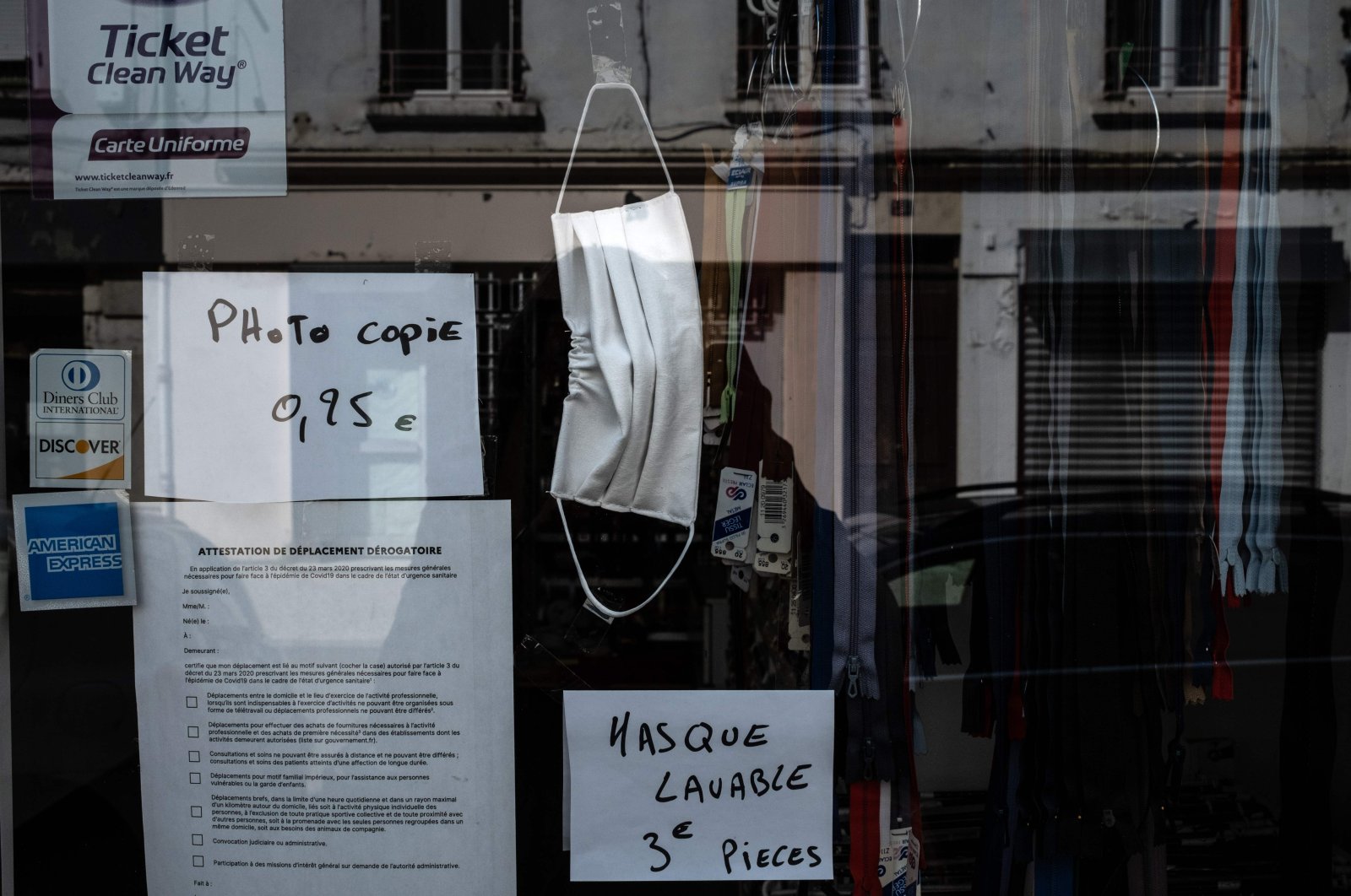 A handmade washable face mask is displayed at the window of a laundry shop, in Givors, France, April 9, 2020. (AFP Photo) 