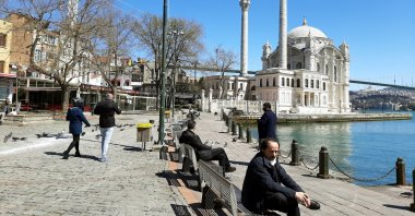 People sit on the benches in Ortaköy, Istanbul, Turkey, April 9, 2020. (Photo by Mustafa Kaya)