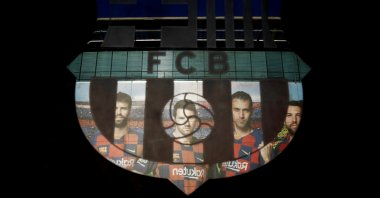 A picture of Lionel Messi with teammates is reflected in the Barcelona emblem outside the stadium before a match, March 7, 2020. (Reuters Photo)