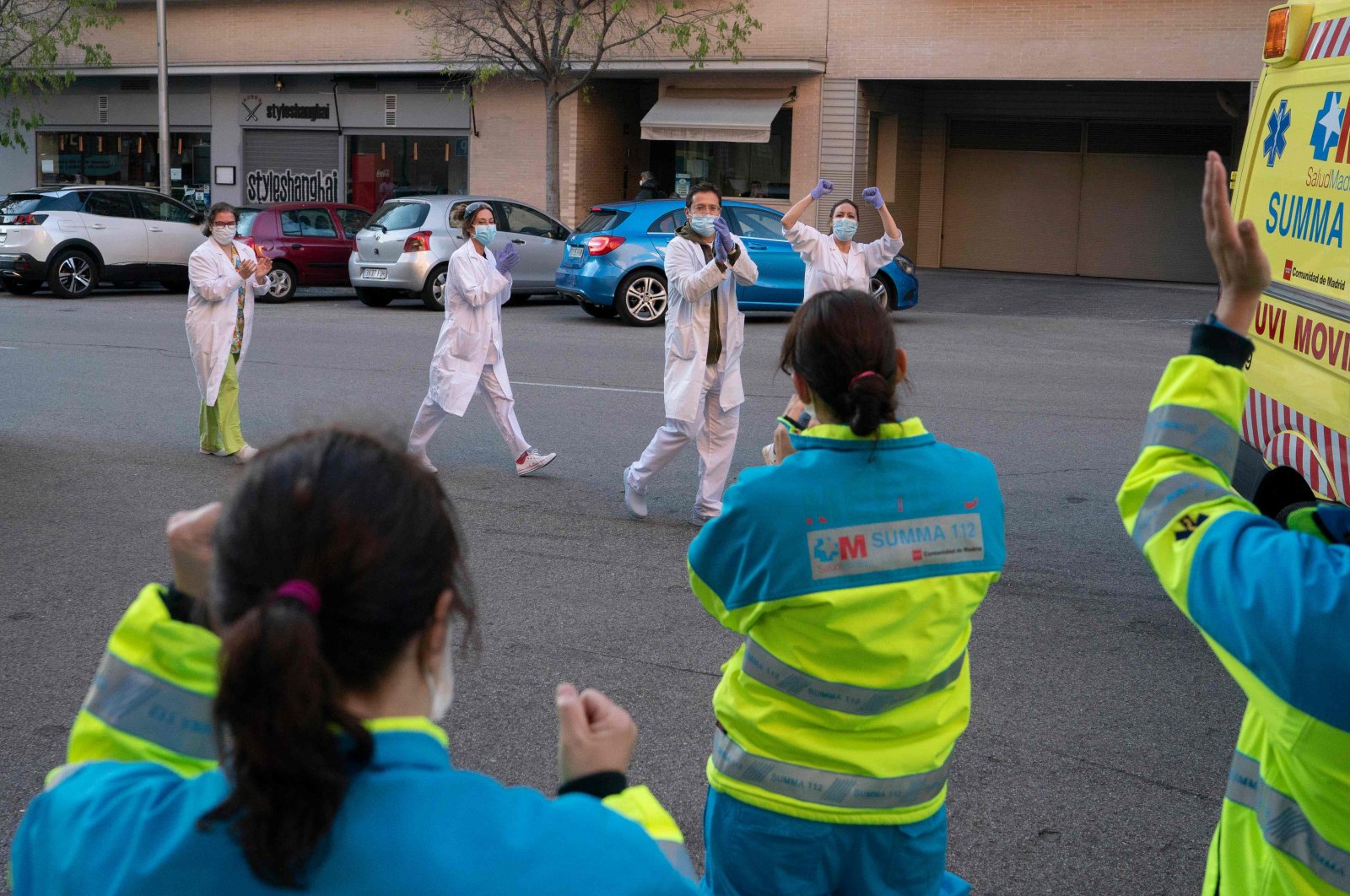 Members of the Comunidad de Madrid's Biological Risk Medical Emergency Service and healthcare workers applaud each other in Madrid, Apr. 9, 2020. (AFP Photo)