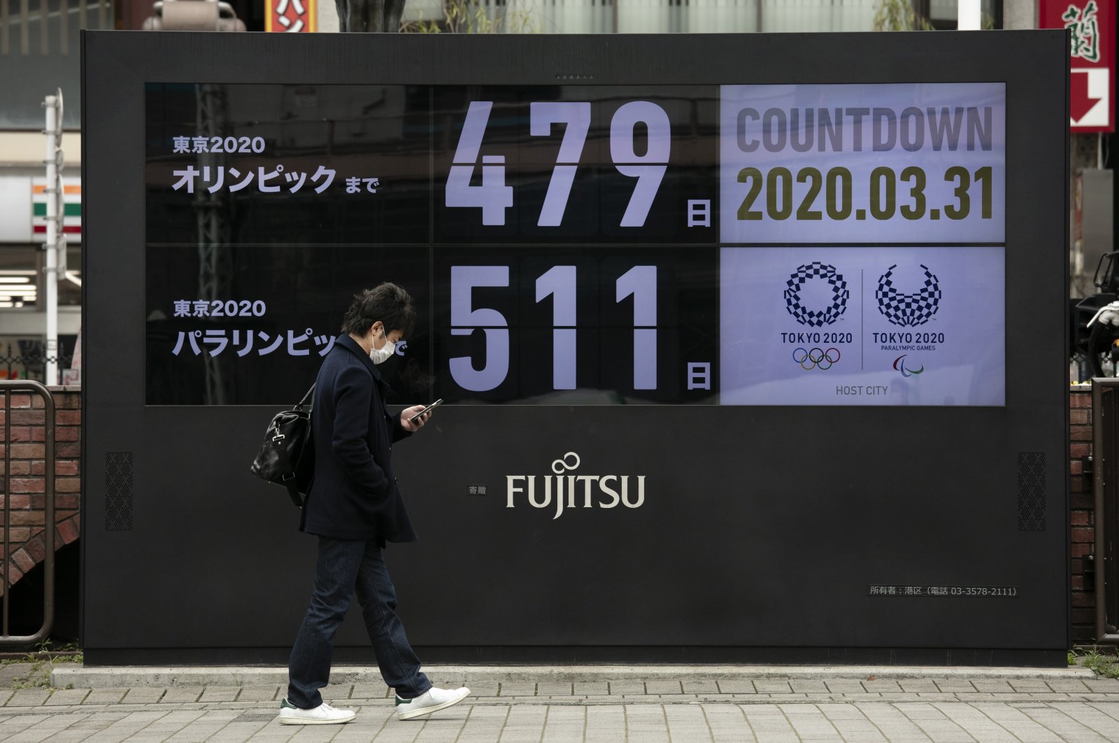 A man walks past a countdown display for the Tokyo 2020 Olympics and Paralympics, Tokyo, March 31, 2020. (AP Photo)