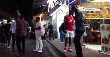 (FILES) This file photo taken on March 2, 2018 shows people gathering on a street in the "Little Africa" district in Guangzhou, the capital of southern China's Guangdong province. (AFP Photo)