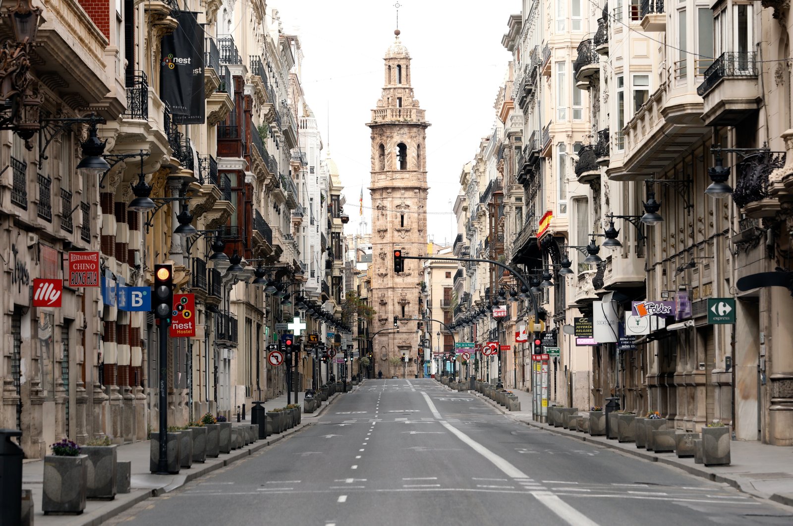 View of a church tower at the end of a deserted street in Valencia, eastern Spain, April 11, 2020. For the first time in centuries, many church bells across Spain will not be ringing on the eve of Easter Sunday, as most bell-ringers won't be able to access their churches and cathedrals due to the nationwide lockdown imposed by the government in a bid to slow down the spread of the pandemic COVID-19 disease. (EPA Photo)