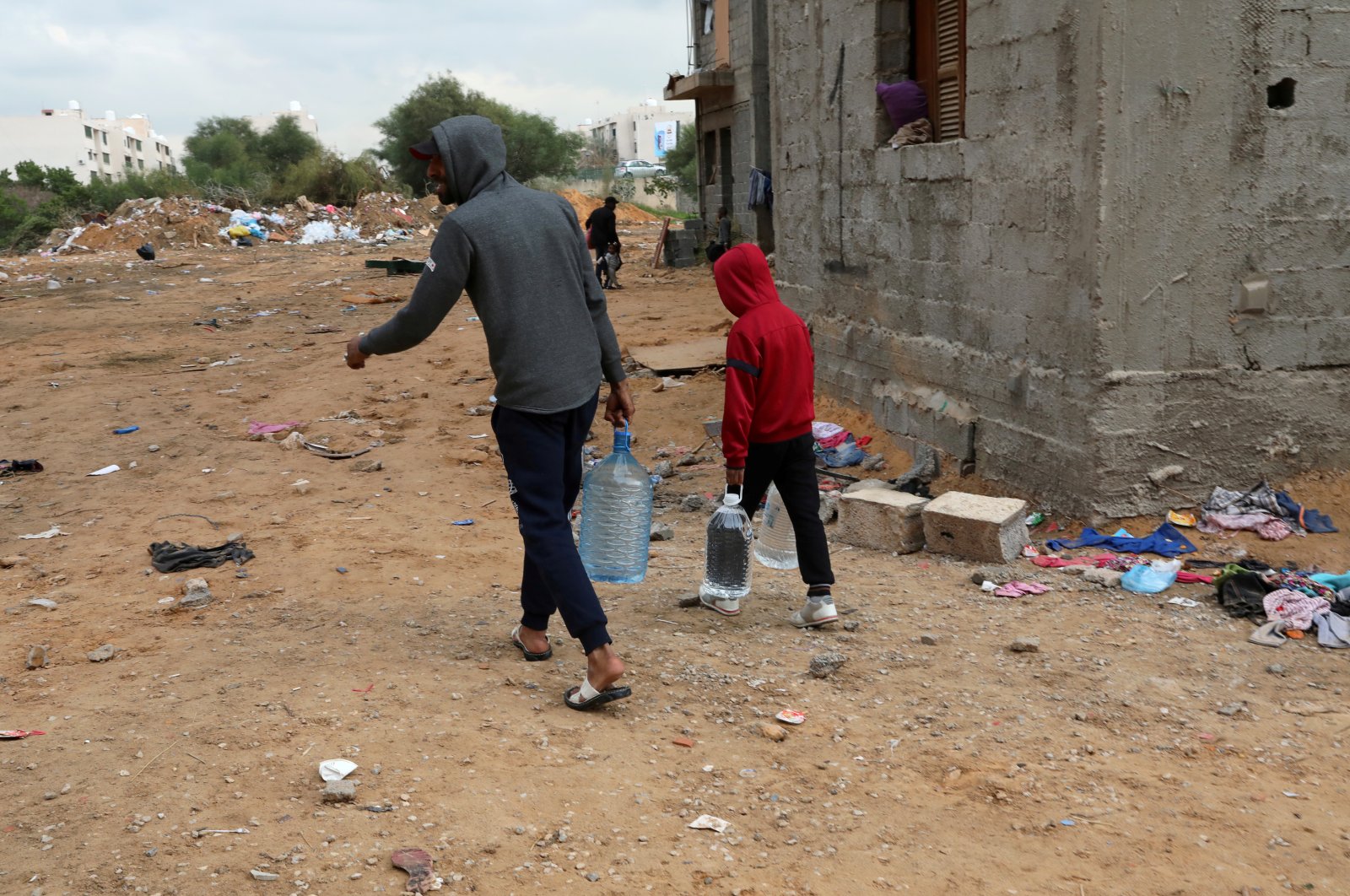 A displaced family as result of Khalifa Haftar's military operation carries gallons of water in Tripoli, Libya, on Jan.16, 2020. Picture taken January 16, 2020. (Reuters Photo)