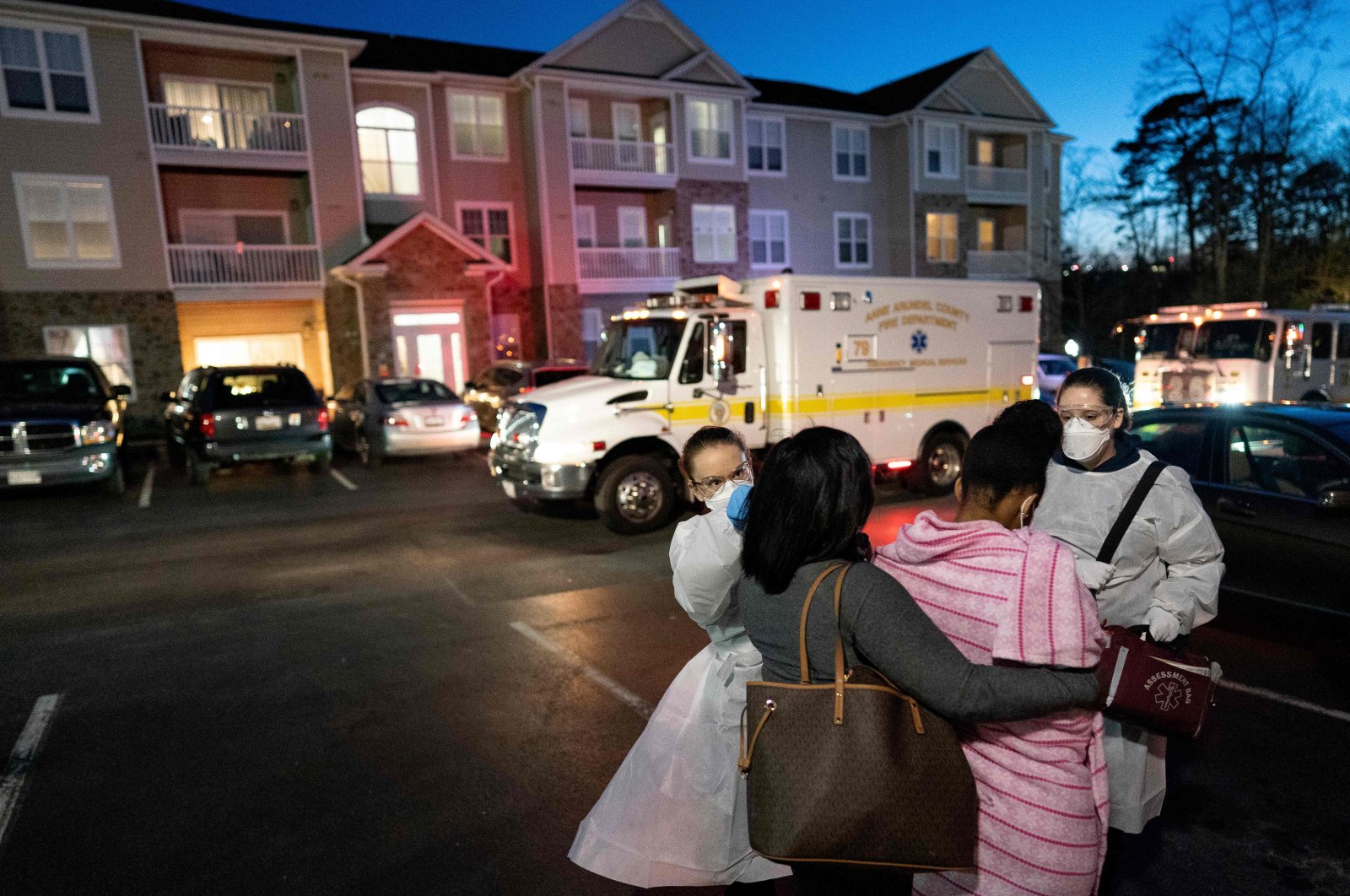 Emergency medical technicians with Anne Arundel County Fire Department assess a young woman experiencing COVID-19 symptoms in Glen Burnie, Maryland on April 10, 2020. (AFP Photo)