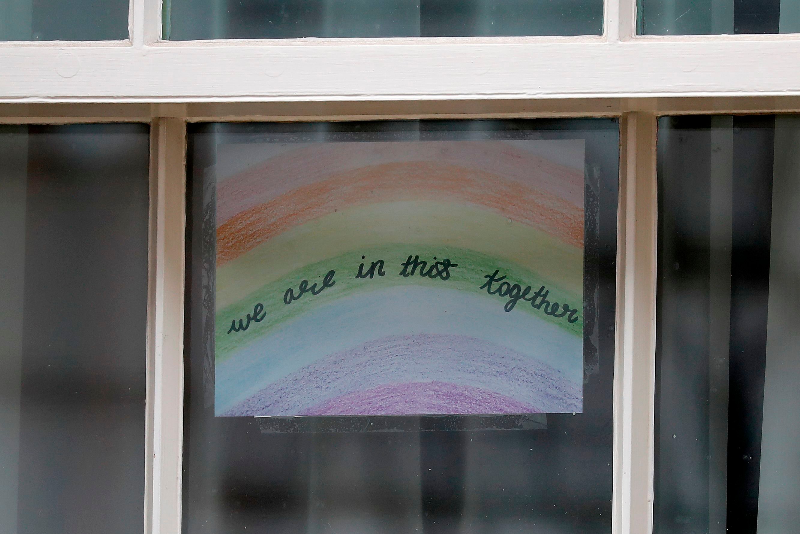 A poster of a rainbow, being used as a symbol of hope during the COVID-19 pandemic, with the words "we are in this together" is pictured in a window at 10 Downing Street, the official residence of Britain