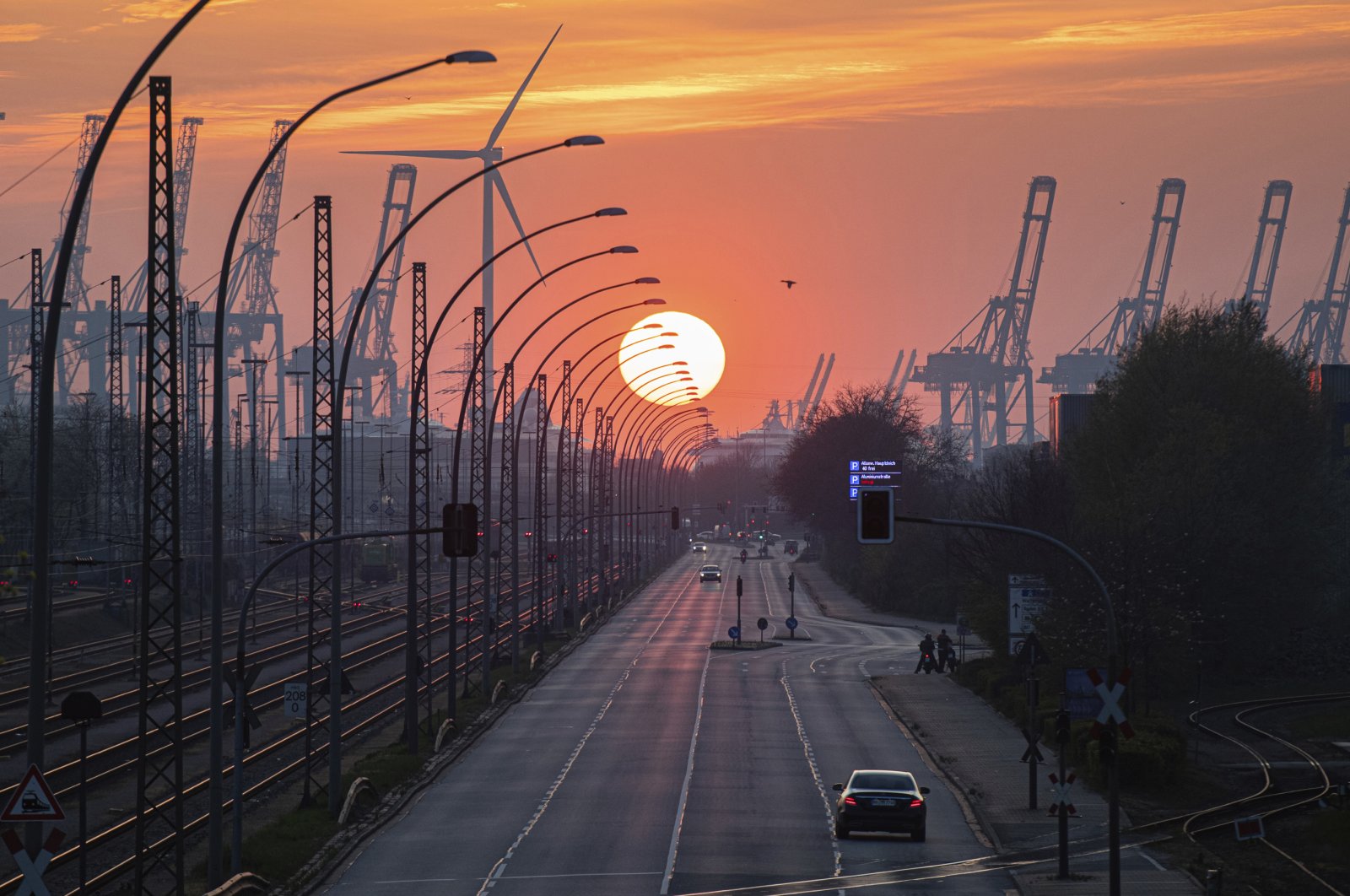 The sun sets behind an industrial cityscape in the port of Hamburg, Germany, April 11, 2020. (AP Photo)