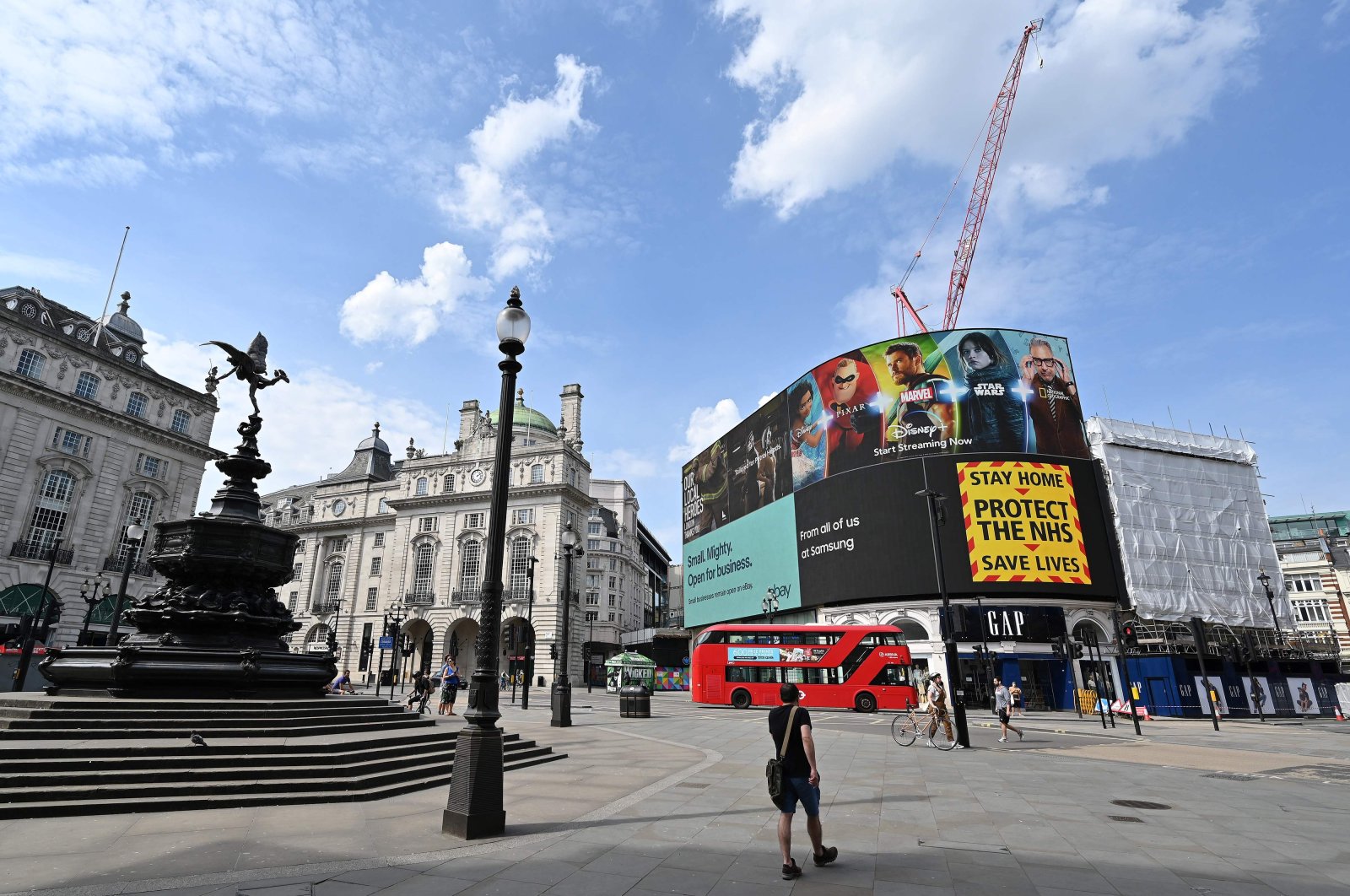 The electronic billboard in Piccadilly Circus displays a notice telling people to "Stay Home. Protect the NHS. Save Lives." near the empty Shaftesbury Memorial Fountain, London, April 12, 2020. (AFP Photo)