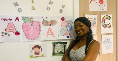 In this undated photo, Della Miles poses with some English materials on the wall of her house.