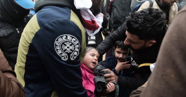A child suffers from tear gas used by Greek riot police outside of a refugee camp in Diavata, a west suburb of Thessaloniki, where migrants gather on April 6, 2019. (AFP Photo)