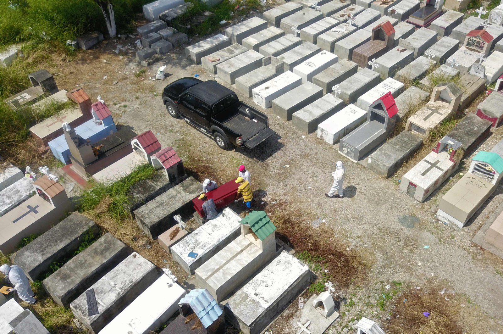 An aerial view of workers burying a coffin at Maria Canals cemetery in the outskirts of Guayaquil, Ecuador, April 12, 2020. (AFP Photo)