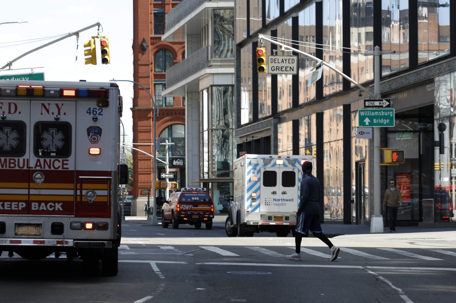 A man crosses the street past New York City Fire Department emergency service trucks and ambulances along West Broadway, New York, April 11, 2020. (EPA Photo)