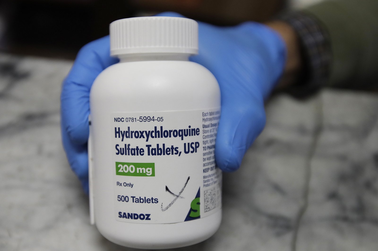 A pharmacist shows a bottle of the drug hydroxychloroquine on Monday, April 6, 2020, in Oakland, California (AP Photo)
