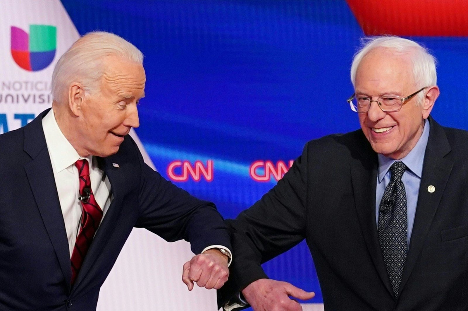 Joe Biden (L) and Senator Bernie Sanders greet each other with a safe elbow bump before the start of the 11th Democratic Party 2020 presidential debate in a CNN Washington Bureau studio in Washington, March 15, 2020. (AFP Photo)