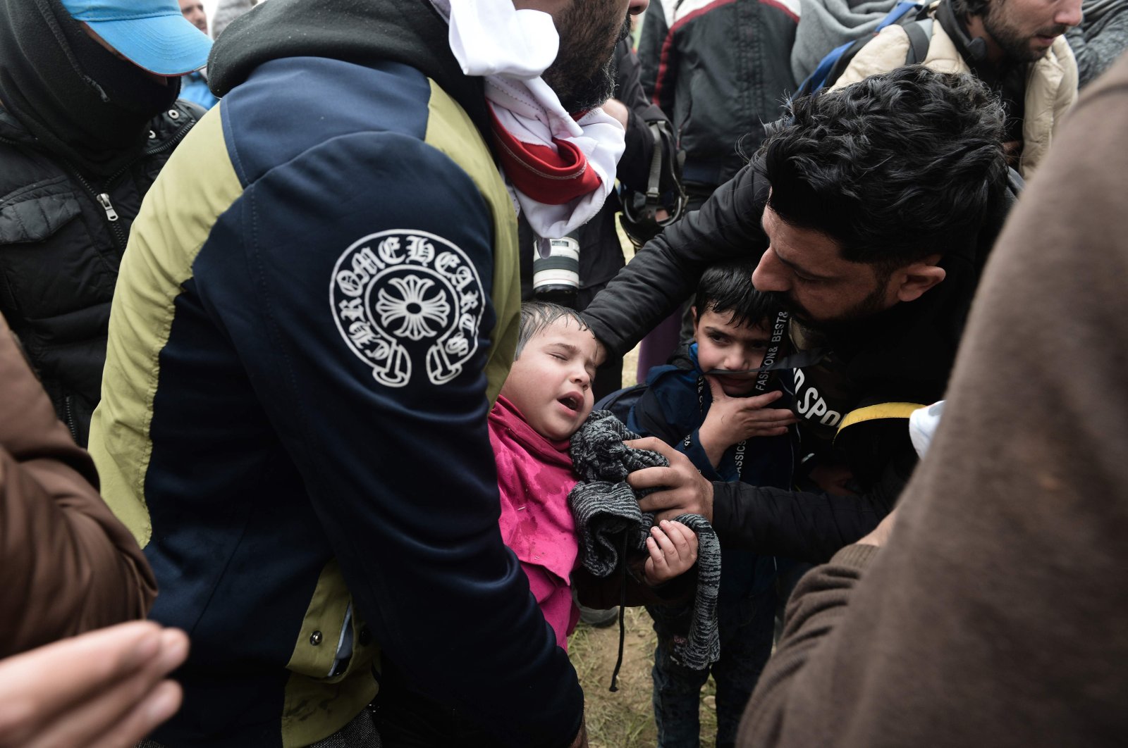 A child suffers from tear gas used by Greek riot police outside of a refugee camp in Diavata, a west suburb of Thessaloniki, where migrants gather on April 6, 2019. (AFP Photo)