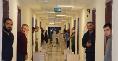 Turkish nationals who arrived from Kuwait and were placed in quarantine, pose at the doors of their rooms at a dormitory in Giresun, Turkey, April 14, 2020. (AA Photo)