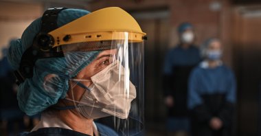 Medical staff gather to cheer patients who have been treated for COVID-19 as they are discharged from the Istanbul University Cerrahpasa medical faculty Hospital, Friday, April 10, 2020. (AFP Photo)
