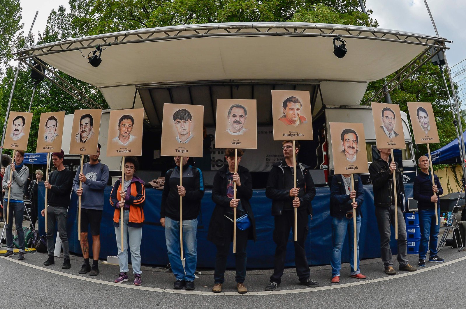 Protesters hold up signs with pictures of the victims of the neo-Nazi cell National Socialist Underground (NSU) before the proclamation of the sentence in the trial against Beate Zschaepe, the only surviving member of the NSU behind a string of racist murders, in Munich, Germany, July 11, 2018. (AFP Photo)