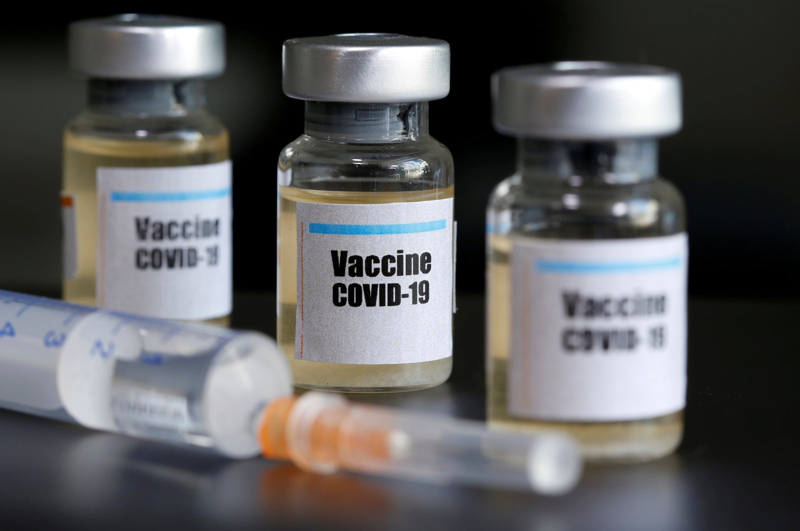 Small bottles labeled with a "Vaccine COVID-19" sticker and a medical syringe are seen in this illustration taken April 10, 2020. (Reuters Photo)