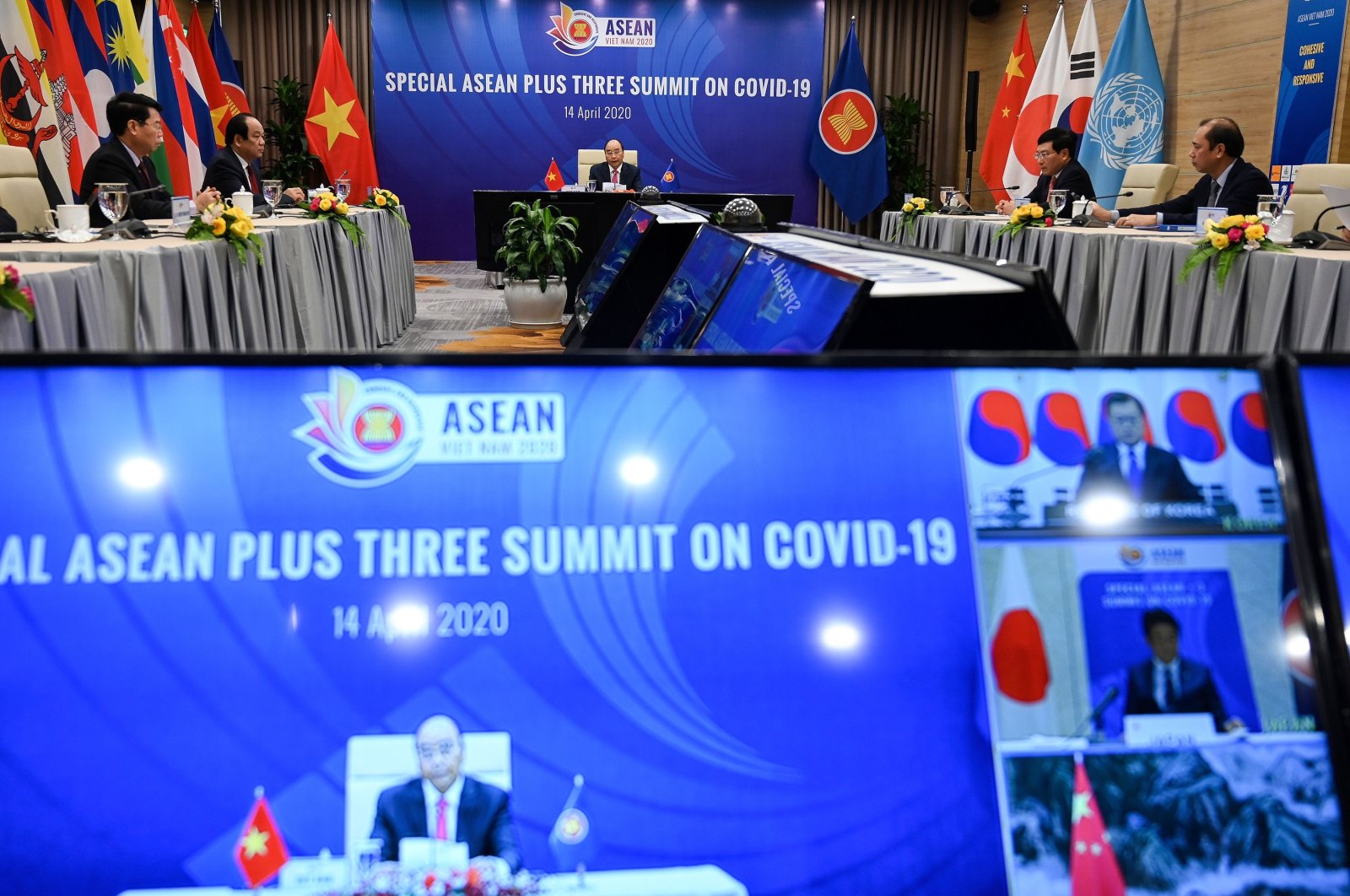Vietnam’s Prime Minister Nguyen Xuan Phuc (C) addresses a live videoconference on the special Association of Southeast Asian Nations (ASEAN) Plus Three Summit on the coronavirus pandemic in Hanoi as South Korea's President Moon Jae-in, Japan's Prime Minister Shinzo Abe and China's Premier Li Keqiang are seen on television screen, April 14, 2020 . (AFP Photo)