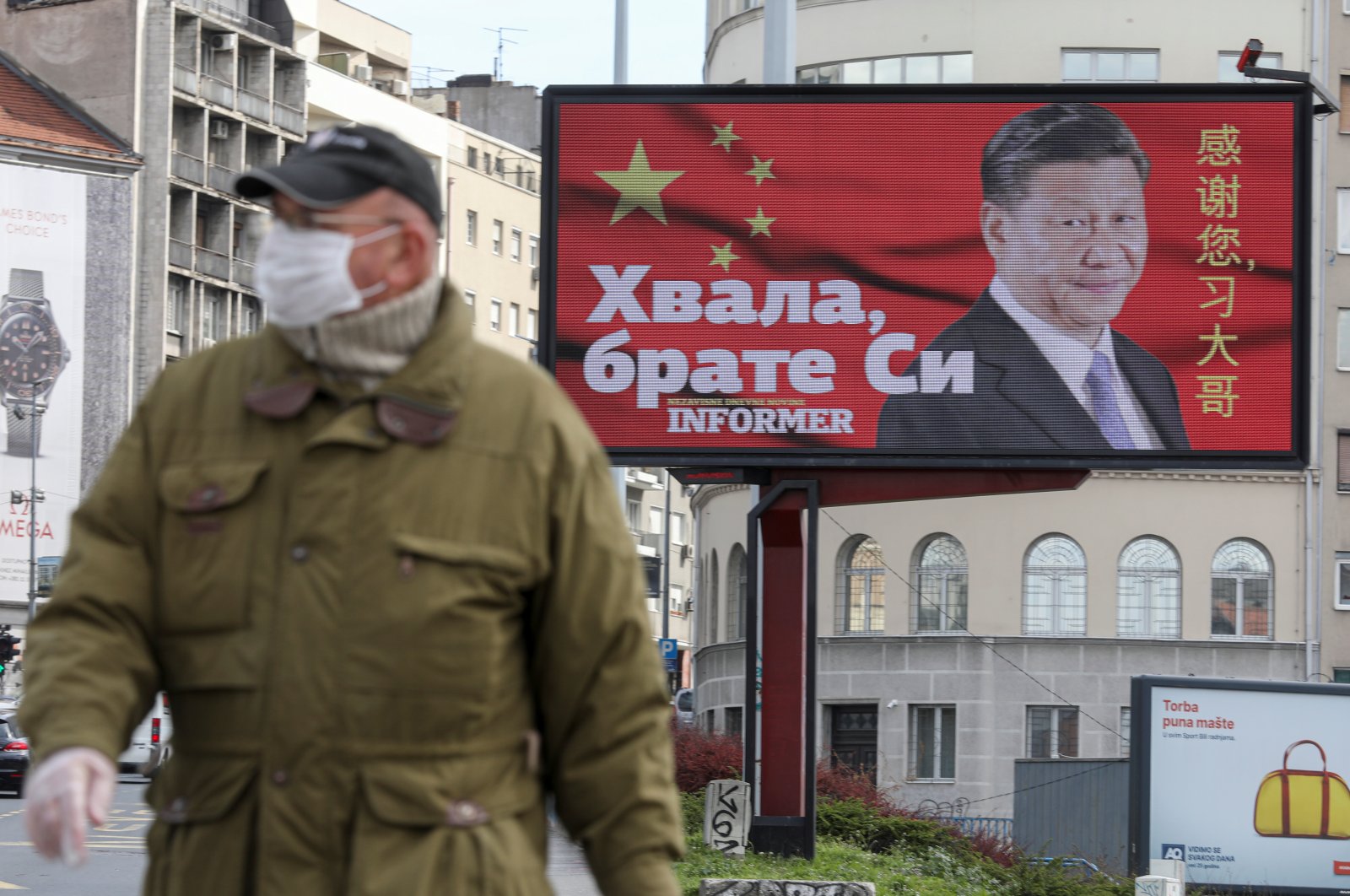 A man wearing a protective mask passes by a billboard depicting Chinese President Xi Jinping that reads "Thanks, brother Xi" amid COVID-19 pandemic, in Belgrade, Serbia, April 1, 2020. (Reuters Photo)