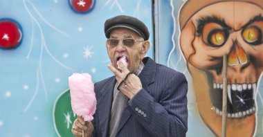 Consuming too much sugar can be scary for our bodies, much like the painted figure behind this old man eating cotton candy at a local amusement park in Istanbul, April 14, 2013. (iStock Photo)
