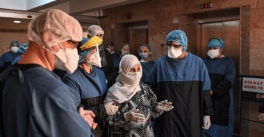 Medical staff cheer as 93-year-old Alye Gündüz (C) is escorted to be discharged from the hospital, in Istanbul, Turkey, April 10, 2020. (AFP Photo)
