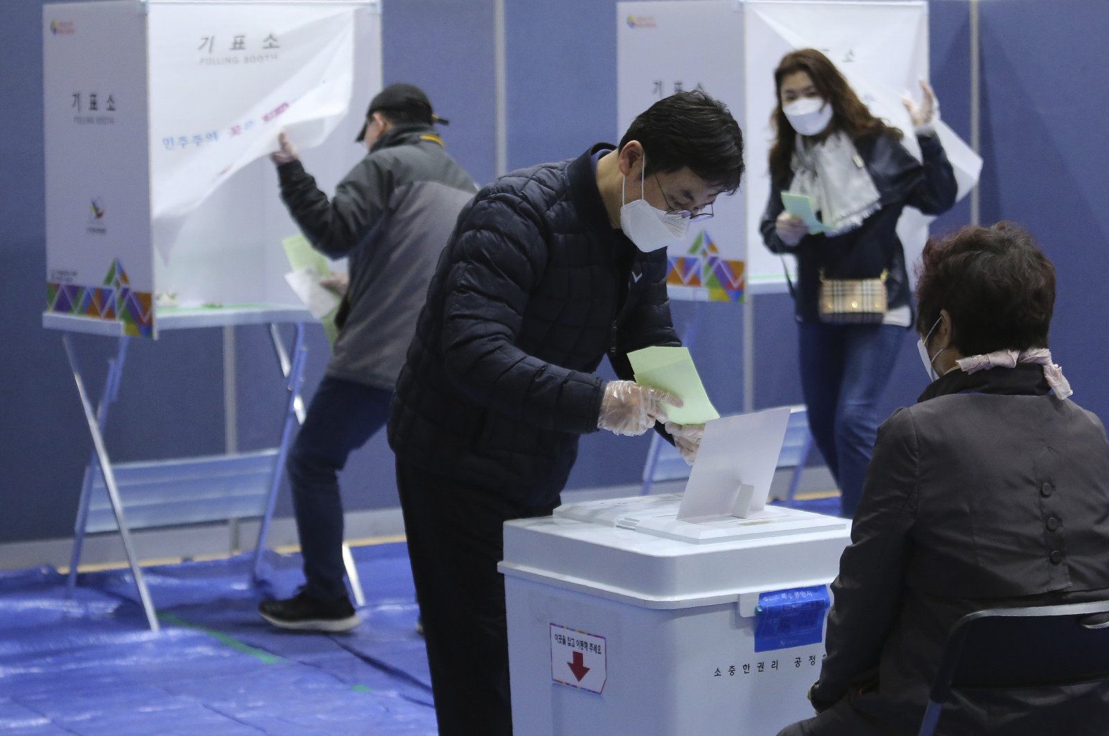 A man wearing a face mask to help protect against the spread of the new coronavirus casts his vote for the parliamentary election at a polling station in Seoul, South Korea, April 15, 2020. (AP Photo)