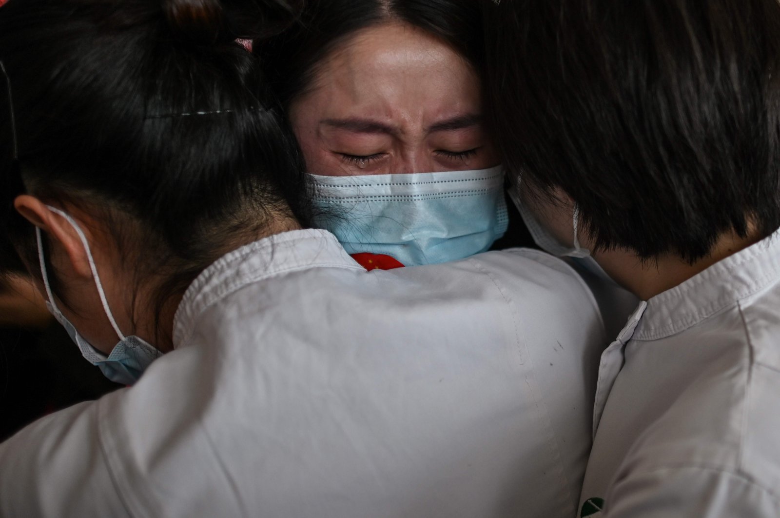 Medical staff from Jilin Province hug nurses from Wuhan after working together during the COVID-19 outbreak during a ceremony before departure at Tianhe Airport in Wuhan, China, April 8, 2020. (AFP Photo)