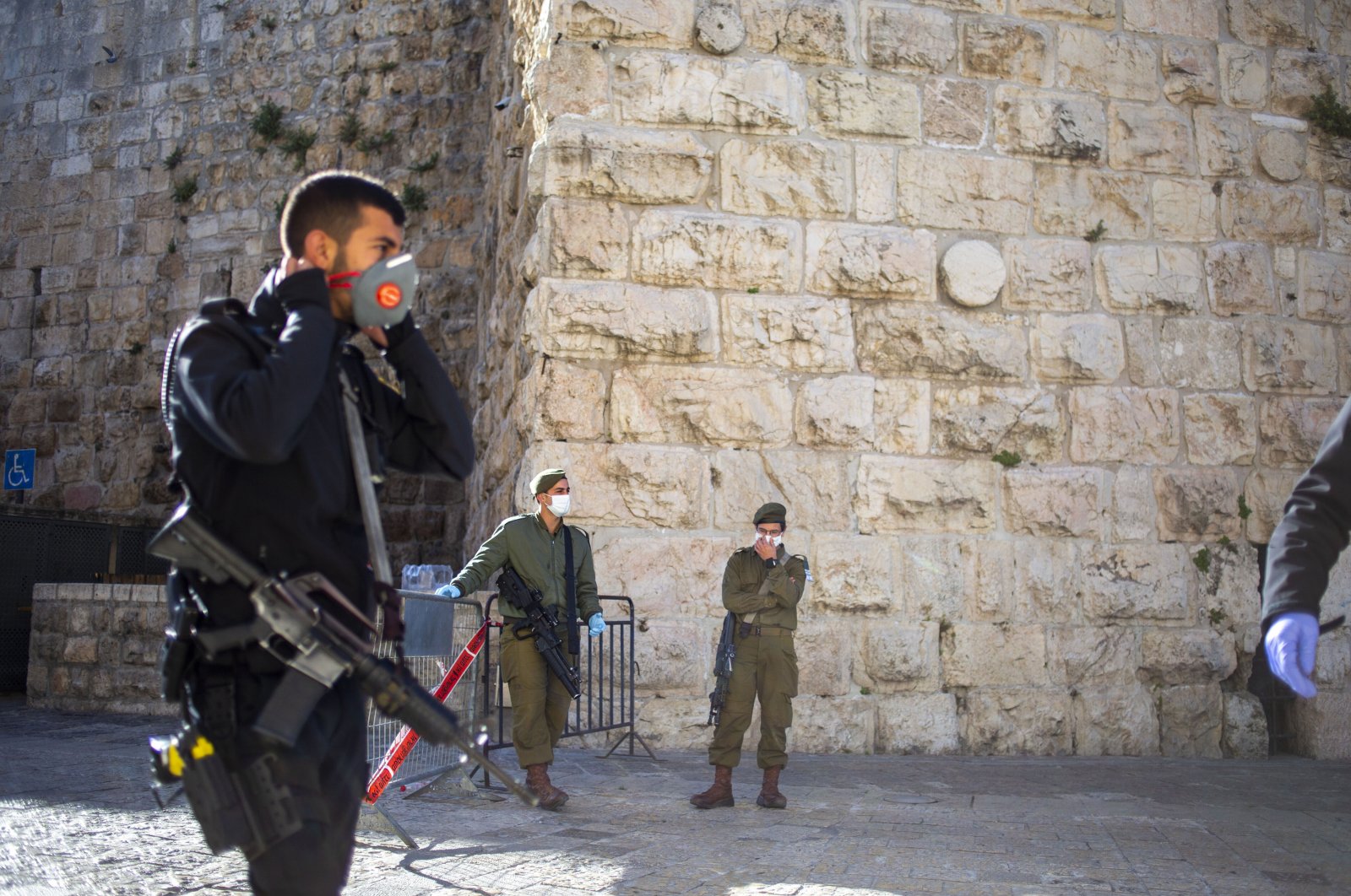 An Israeli police officer and Israeli soldiers block Jaffa gate during a lockdown following government measures in Jerusalem's old city, April 9, 2020. (AP Photo)
