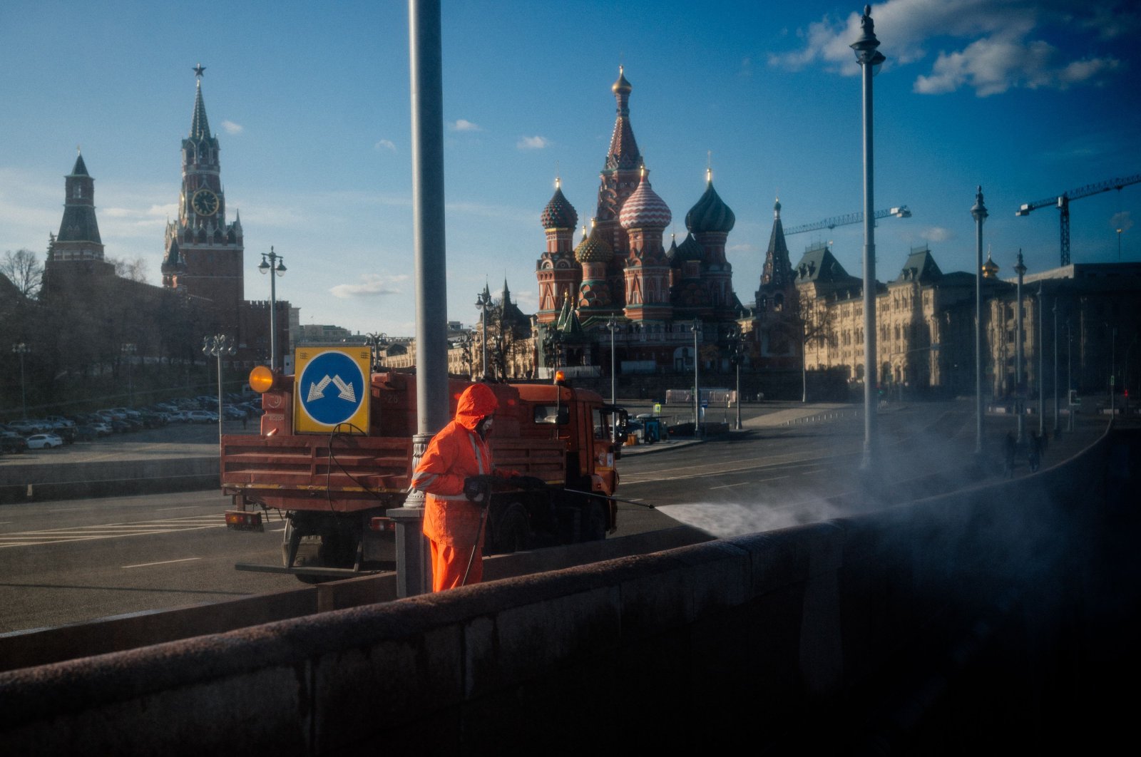 A municipal worker cleans and disinfects a bridge near the Kremlin in downtown Moscow on April 12, 2020, during a strict lockdown in Russia to stop the spread of the novel coronavirus COVID-19. (AFP Photo)
