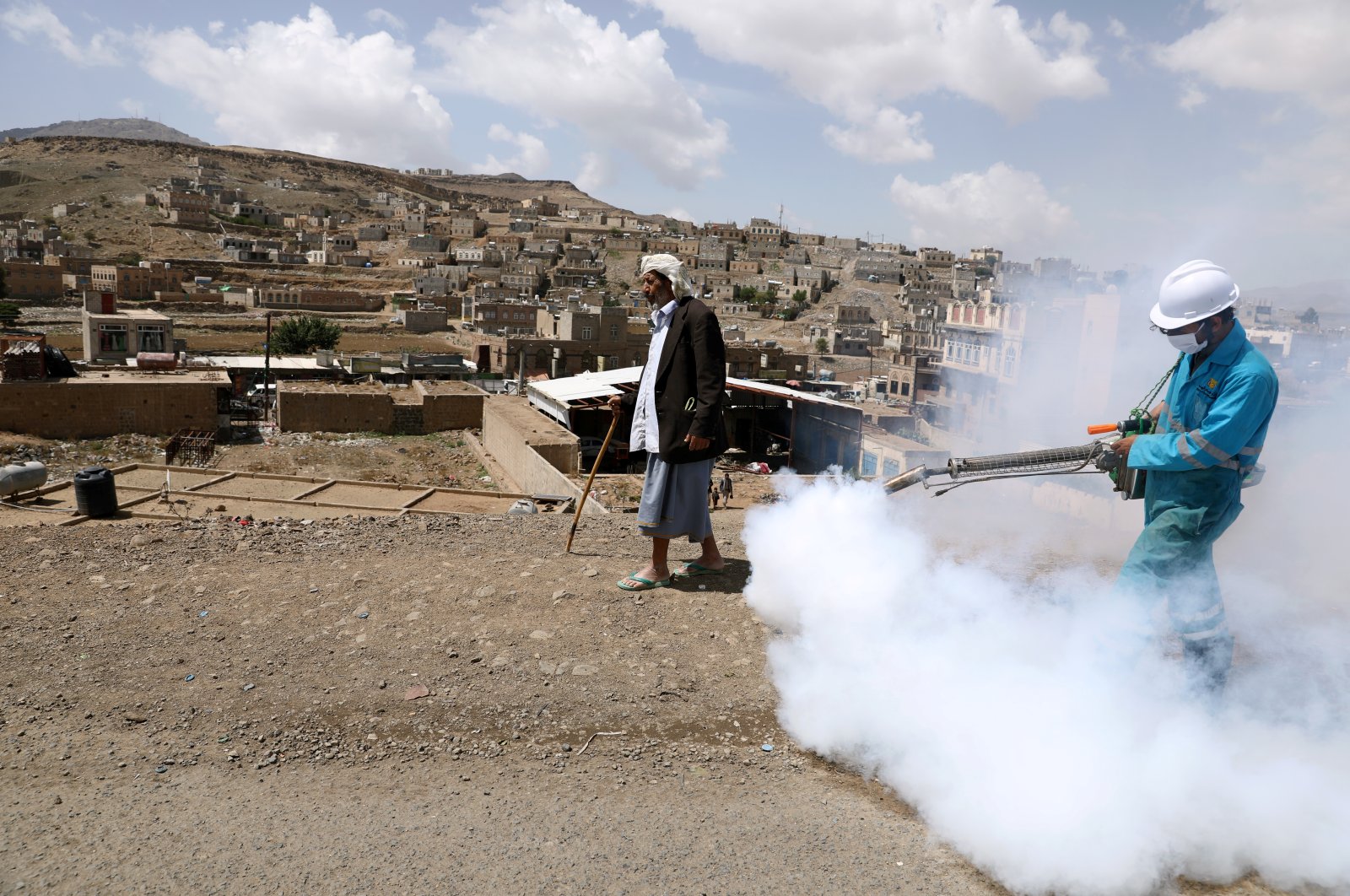 A health worker disinfects residential area during a sanitation campaign to prevent the spread of the coronavirus disease (COVID-19), on the outskirts of Sanaa, Yemen April 13, 2020. Picture taken April 13, 2020. (Reuters Photo) 
